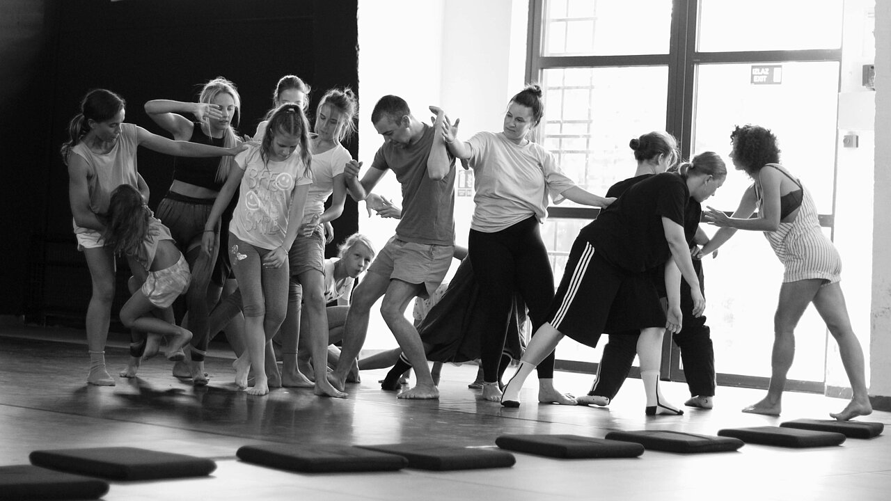 a group of dancers, holding on to each other, black and wihite.