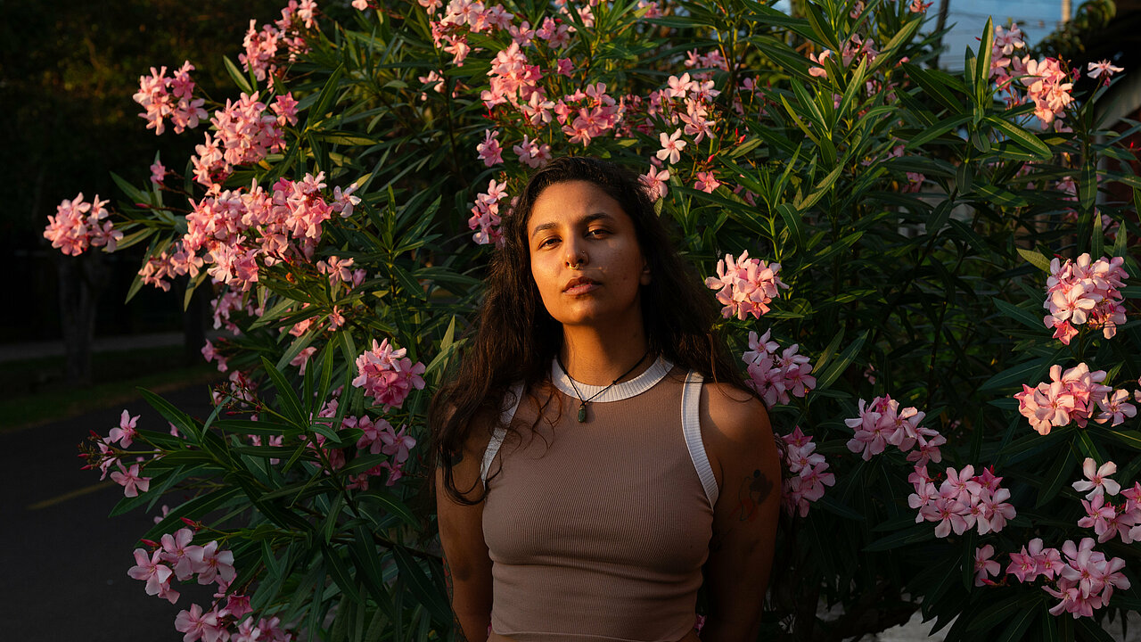 Portrait of Andrea Vezga in front of blooming tree, during golden hour